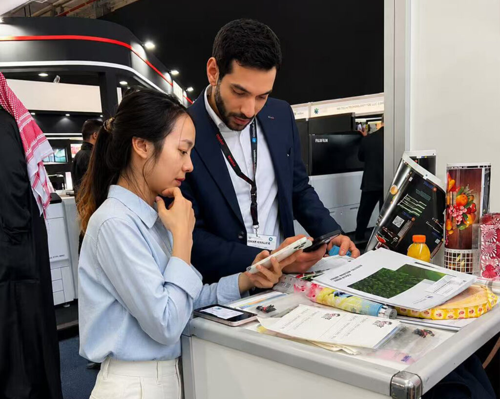 GGIN Machinery sales team discussing flexographic printing solutions with international buyer at trade show